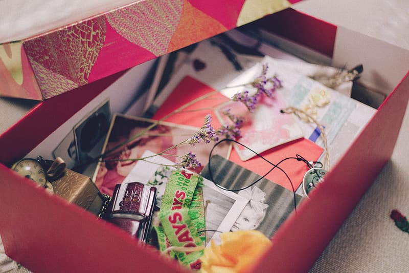 Pink cardboard box filled with cards and items in memory of a loved one