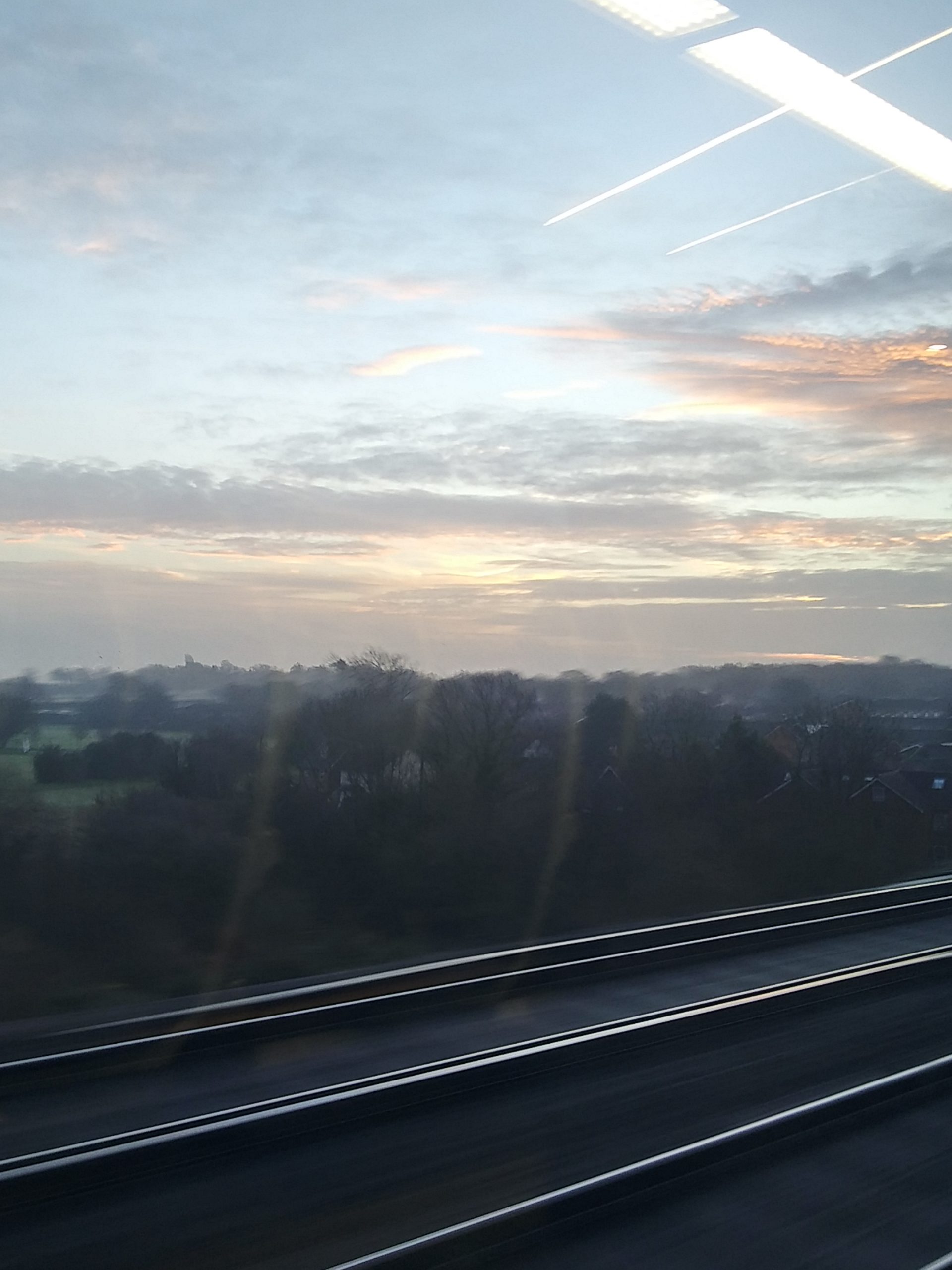 light blue sky featuring a sunrise on my morning train ride to the airport
